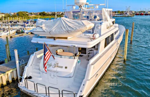 Back end view of white yacht named Lady Grace docked in a harbor