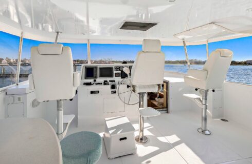 Bridge of a yacht with white flooring, walls, and chairs