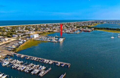 Aerial view of multiple marinas with a large red arrow pointing down to the Lady Grace Yacht that is docked at one of the marinas