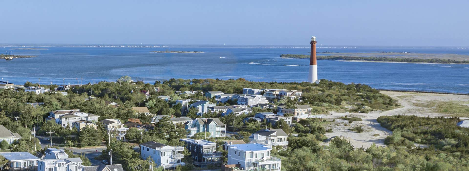 View of a small coastal town with a lighthouse and water in the background