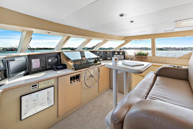 Bridge of yacht with tan carpeted flooring, tan walls, and tan leather chair