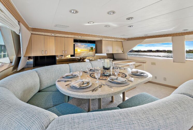 Yacht's kitchen booth with teal upholstered cushions and light tan quartz table