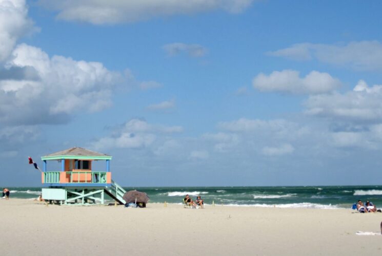 Colorful lifeguard station on a white sand beach with rolling ocean waves in the background